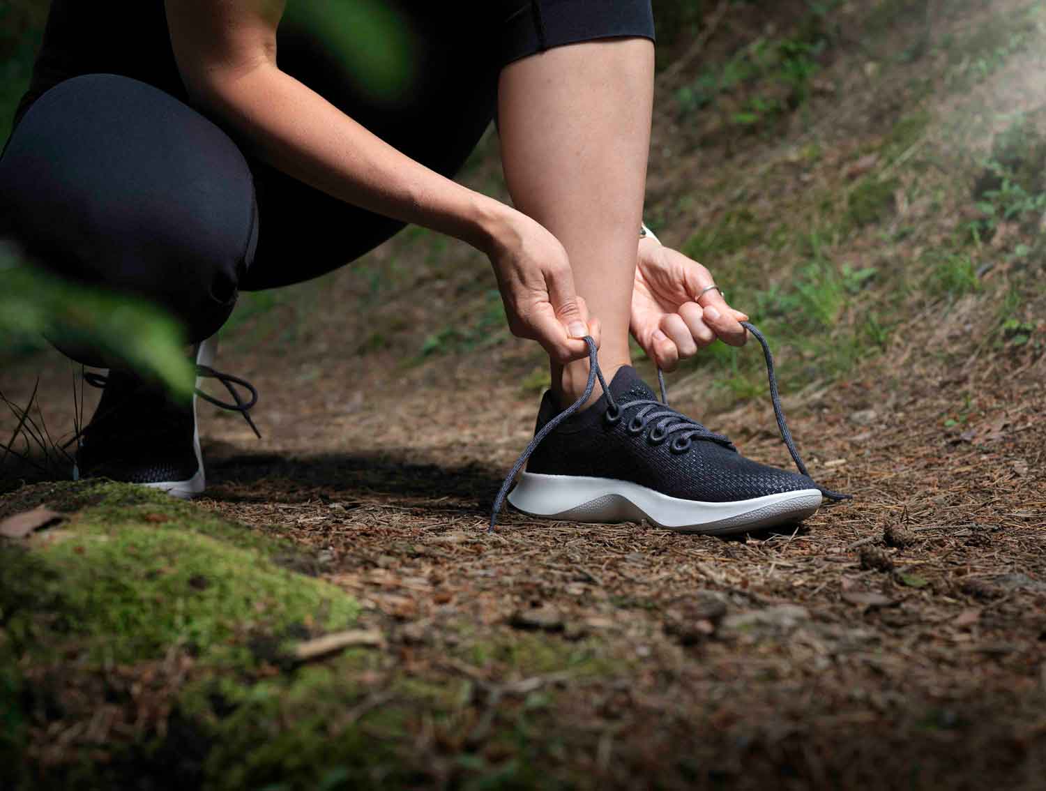 Dame die Schuhe festbindet im Wald